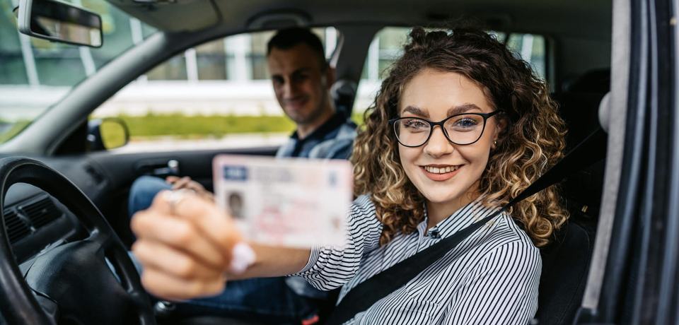 new driver holding up license (slim)