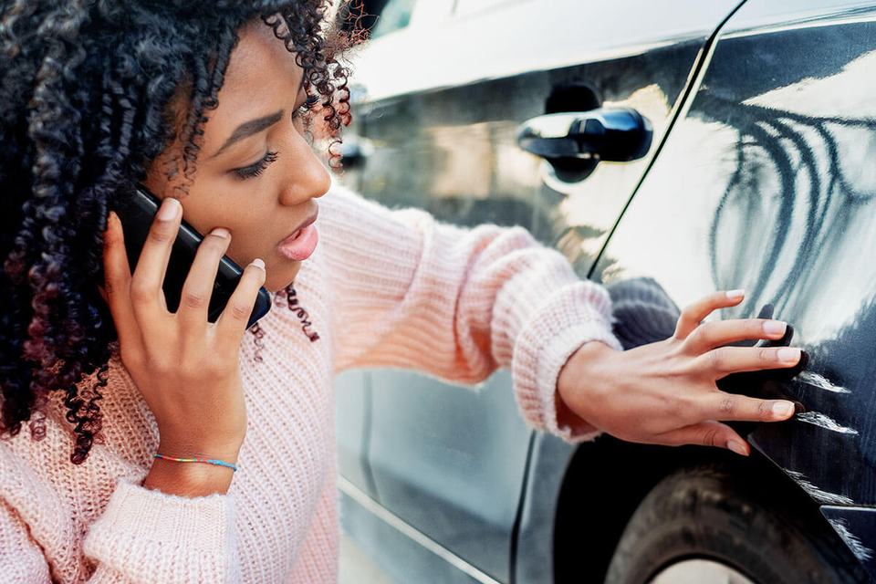 Woman-looking-at-scratch-on-car