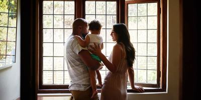 couple-and-child-looking-out-window-of-home.jpg
