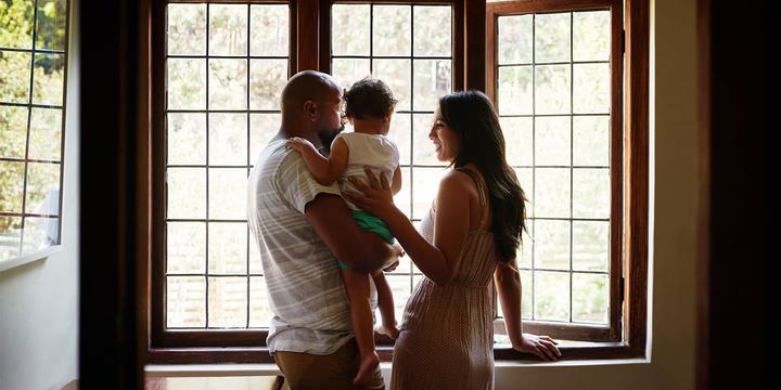 couple-and-child-looking-out-window-of-home.jpg