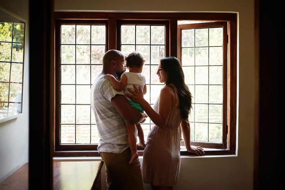 couple-and-child-looking-out-window-of-home.jpg