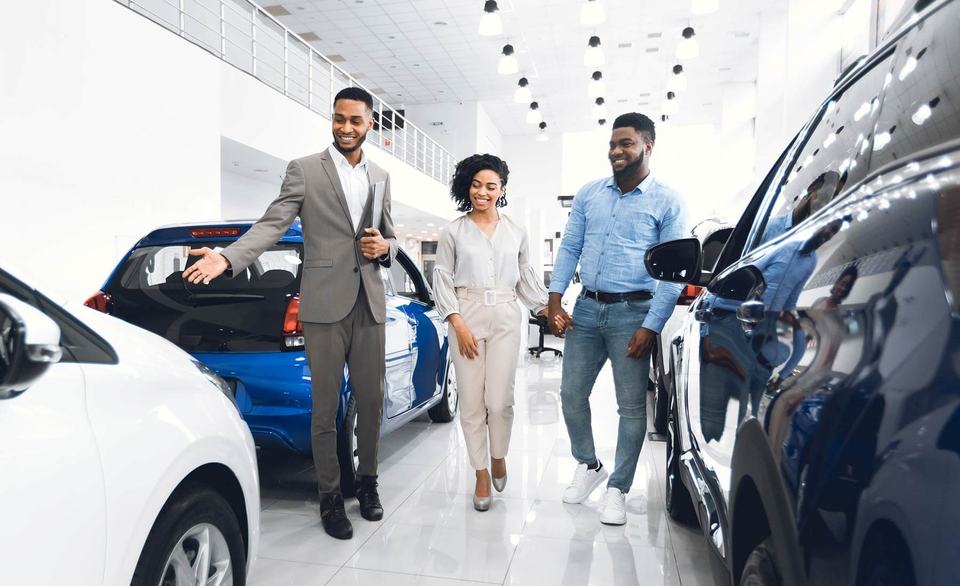 A couple purchasing a car at a car dealership