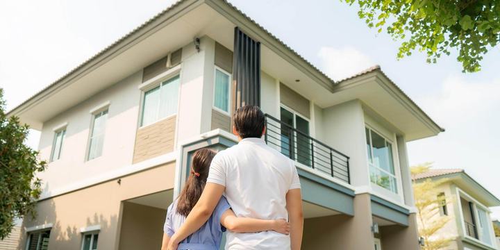 couple-standing-in-front-of-house