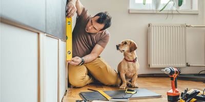man-using-level-for-home-improvement-project-with-dog.jpg