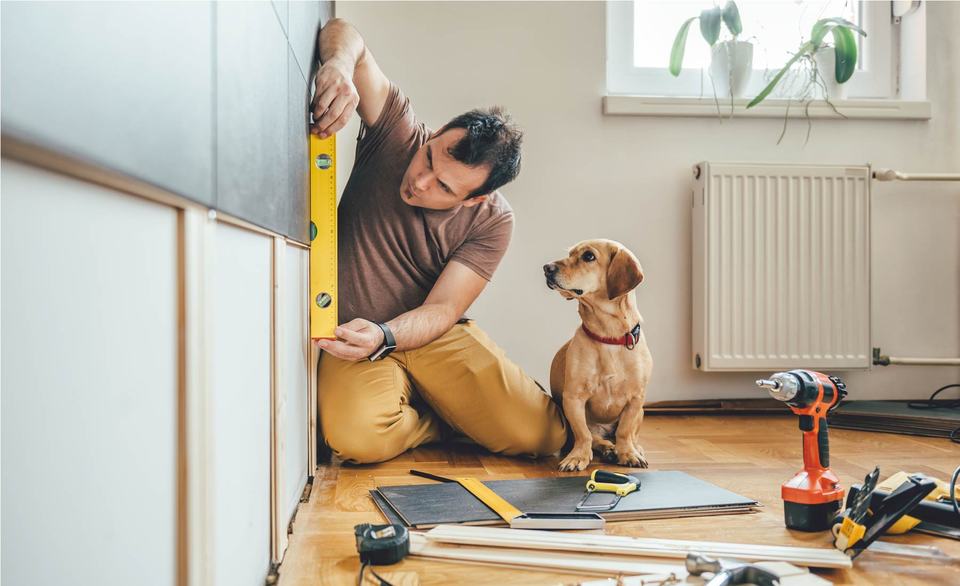 man-using-level-for-home-improvement-project-with-dog.jpg