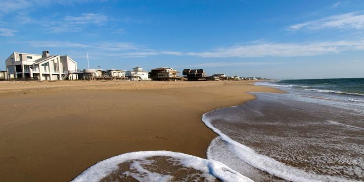 ocean-waves-on-beach-next-to-coastal-homes.jpg