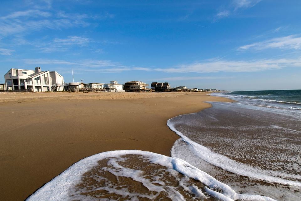 ocean-waves-on-beach-next-to-coastal-homes.jpg