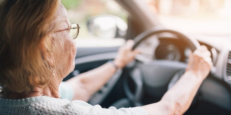 senior woman with glasses driving