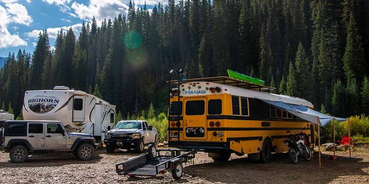 A skoolie parked at a campground.