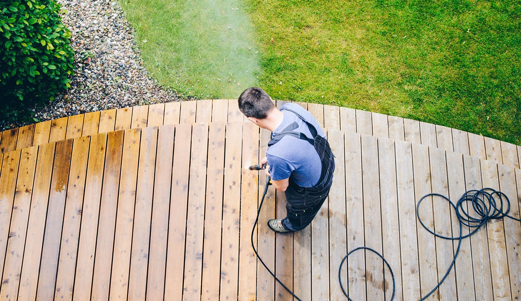 Man powerwashing an outdoor deck