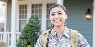 veteran-standing-outside-her-home-smiling-2.jpg