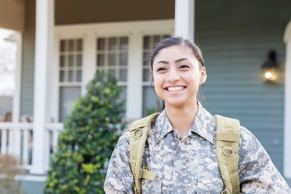 veteran-standing-outside-her-home-smiling-2.jpg
