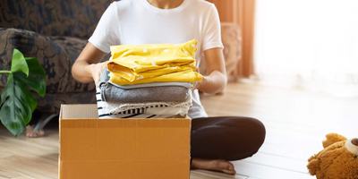 woman-placing-folded-clothes-in-cardboard-box.jpg