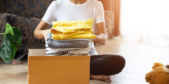 woman-placing-folded-clothes-in-cardboard-box.jpg